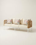 Modern sofa with floral cushions on a plain background