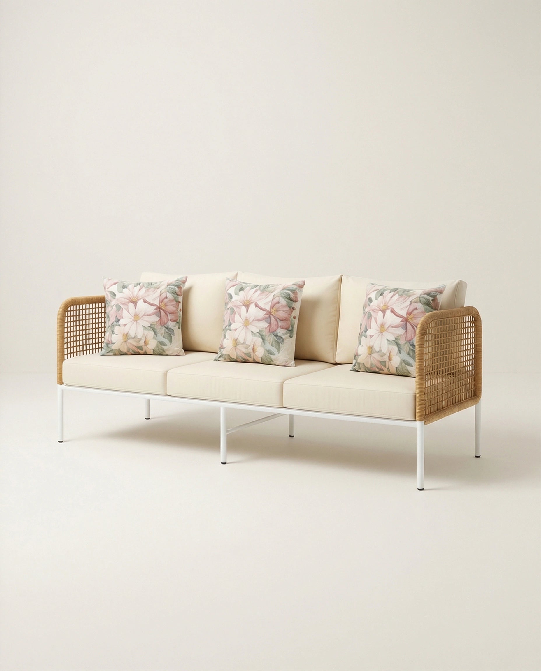 Modern sofa with floral cushions on a plain background