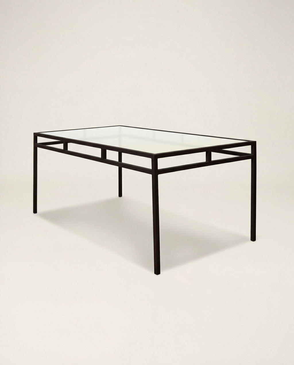 Glass table with black metal frame on a beige background