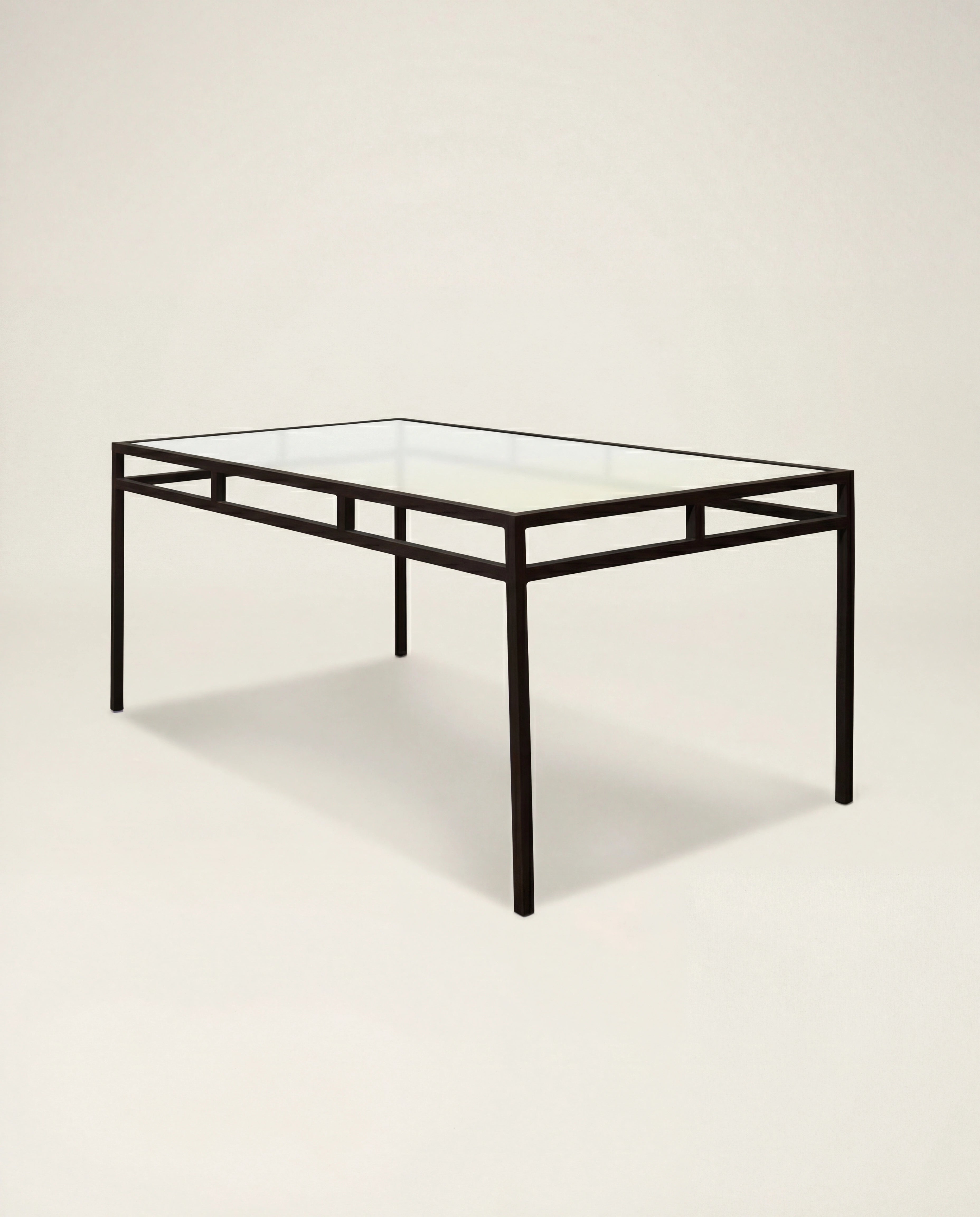Glass table with black metal frame on a beige background